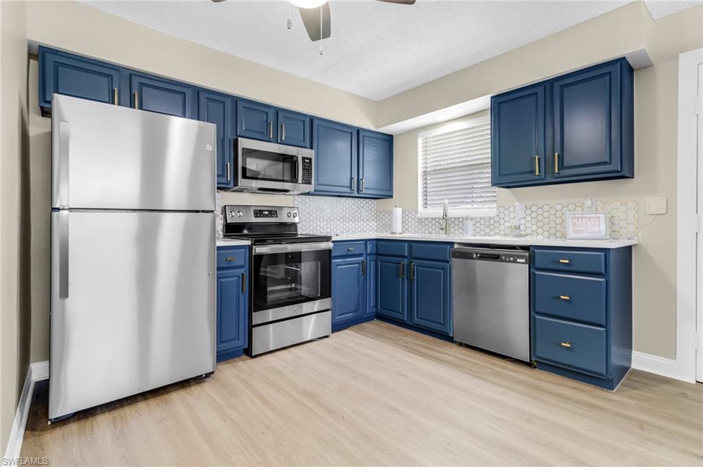 a kitchen with stainless steel appliances granite countertop a refrigerator stove a sink dishwasher and microwave