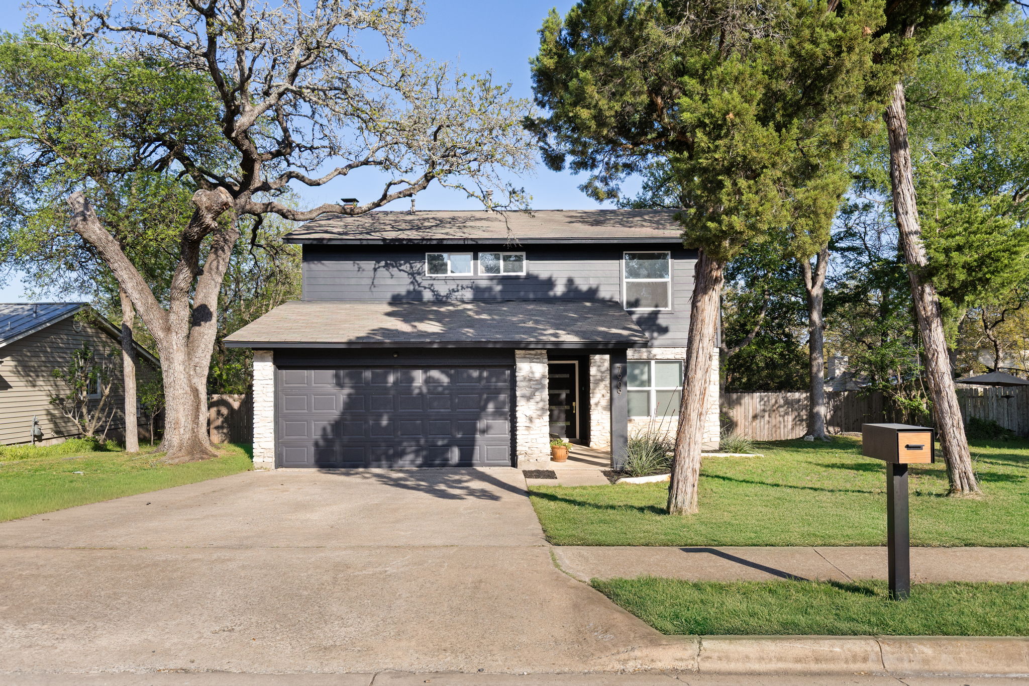 Traditional-style home featuring driveway, a garage, and a shingled roof