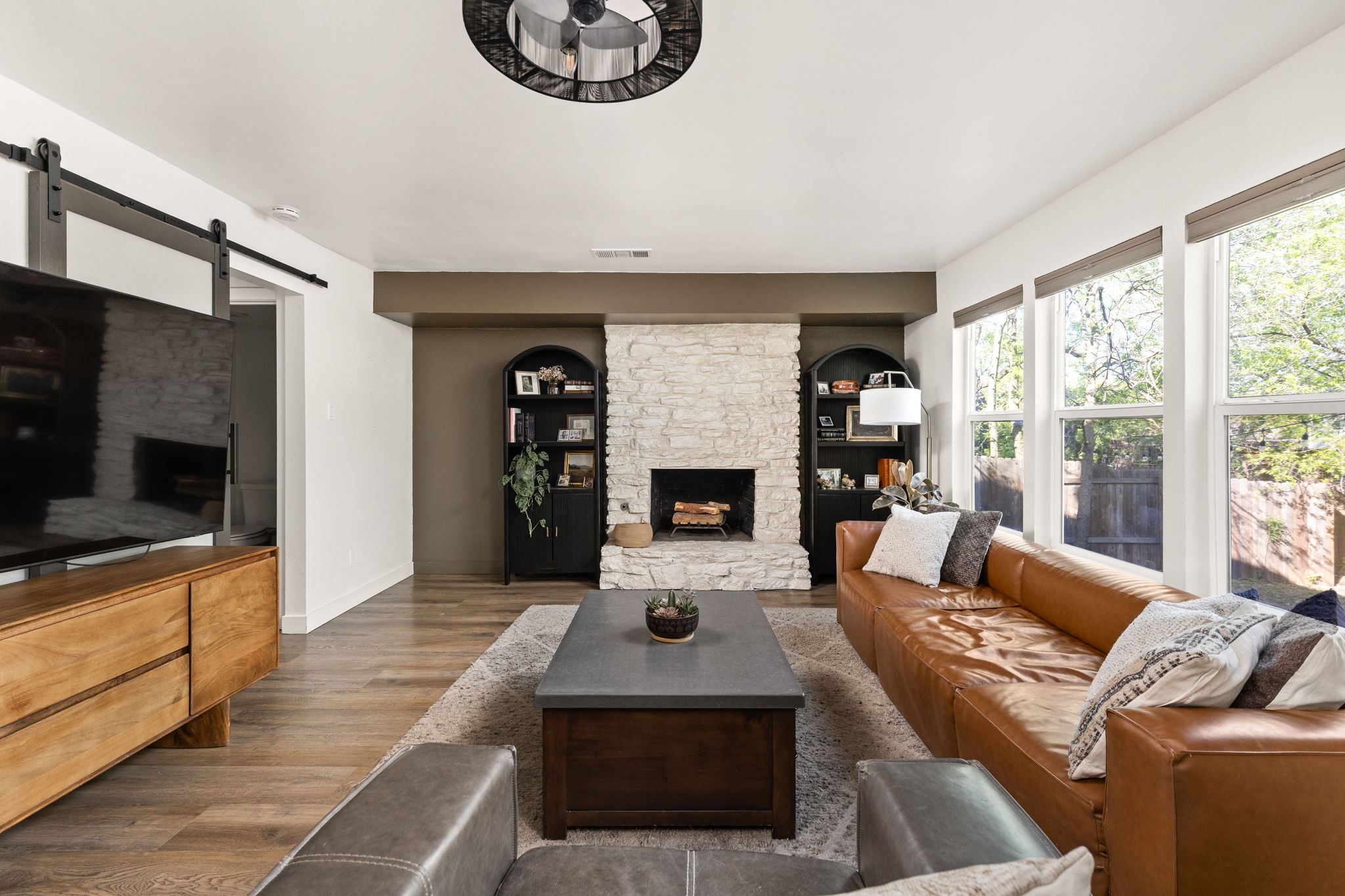 7909 Manassas Drive Austin, TX 78745 - Photo 12 of 37 Living room with a fireplace, a barn door, and wood finished floors