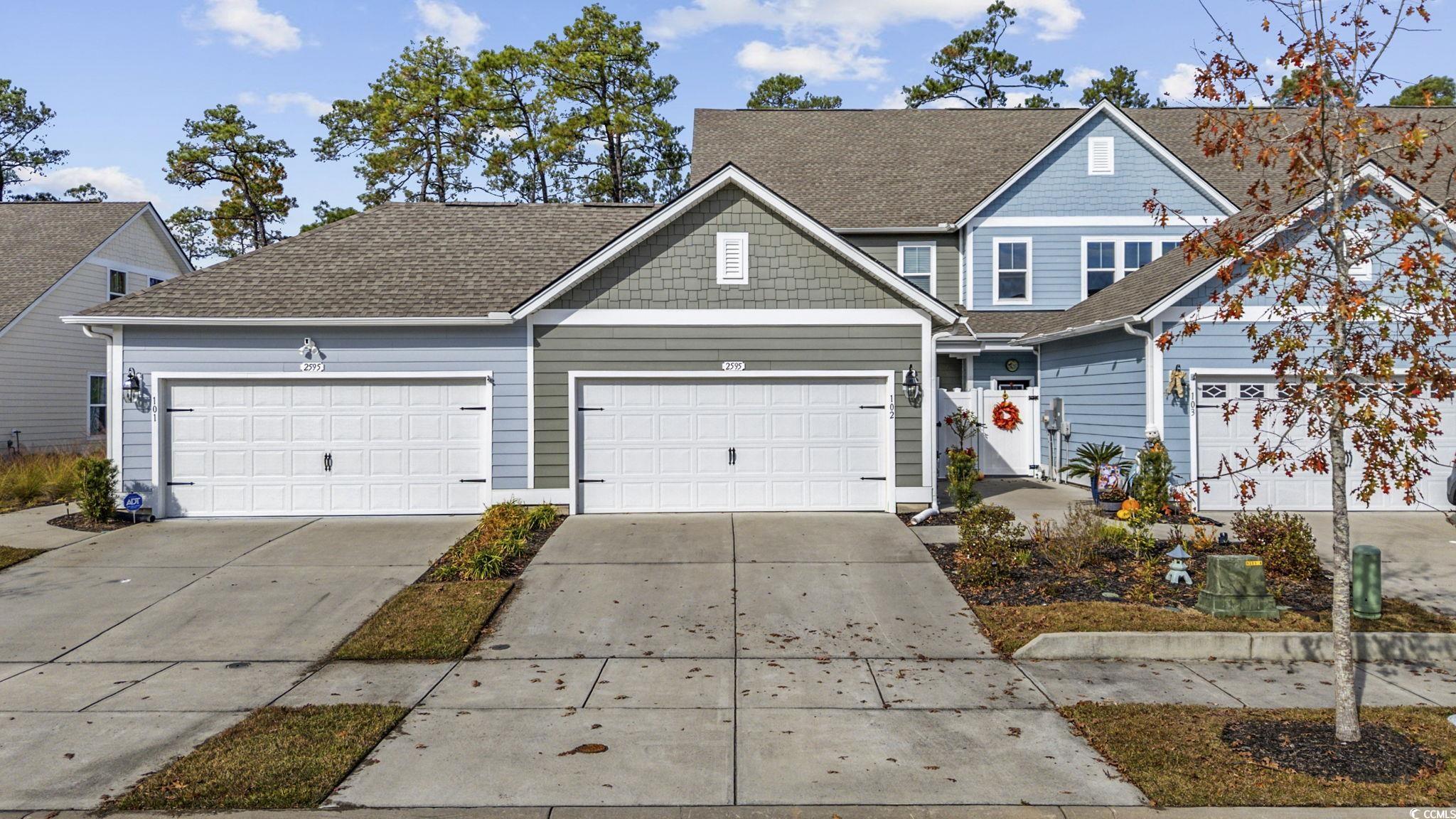 View of front of home with concrete driveway and roof with shingles