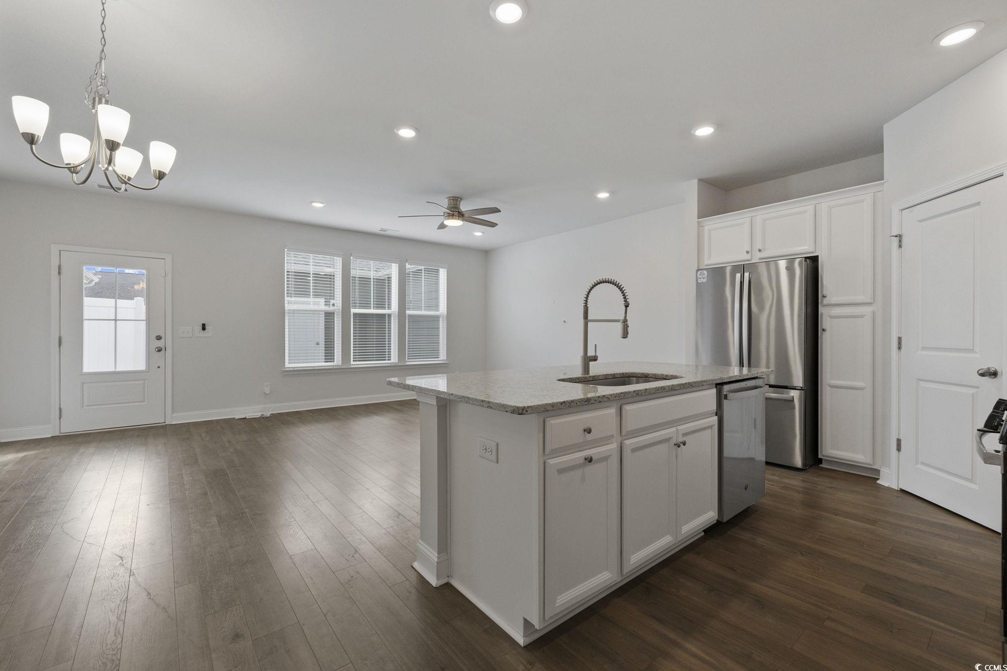 2595 Blue Crane Circle, Unit 102 Myrtle Beach, SC 29577 - Photo 40 of 40 Kitchen featuring white cabinetry, a kitchen island with sink, open floor plan, ceiling fan, and pendant lighting
