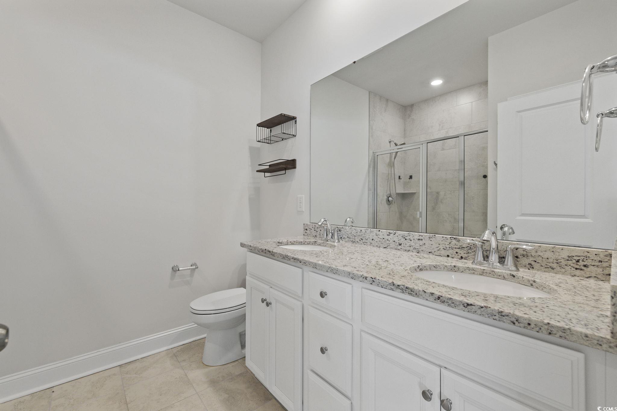 2595 Blue Crane Circle, Unit 102 Myrtle Beach, SC 29577 - Photo 19 of 40 Full bathroom featuring double vanity, a stall shower, light tile patterned floors, and recessed lighting