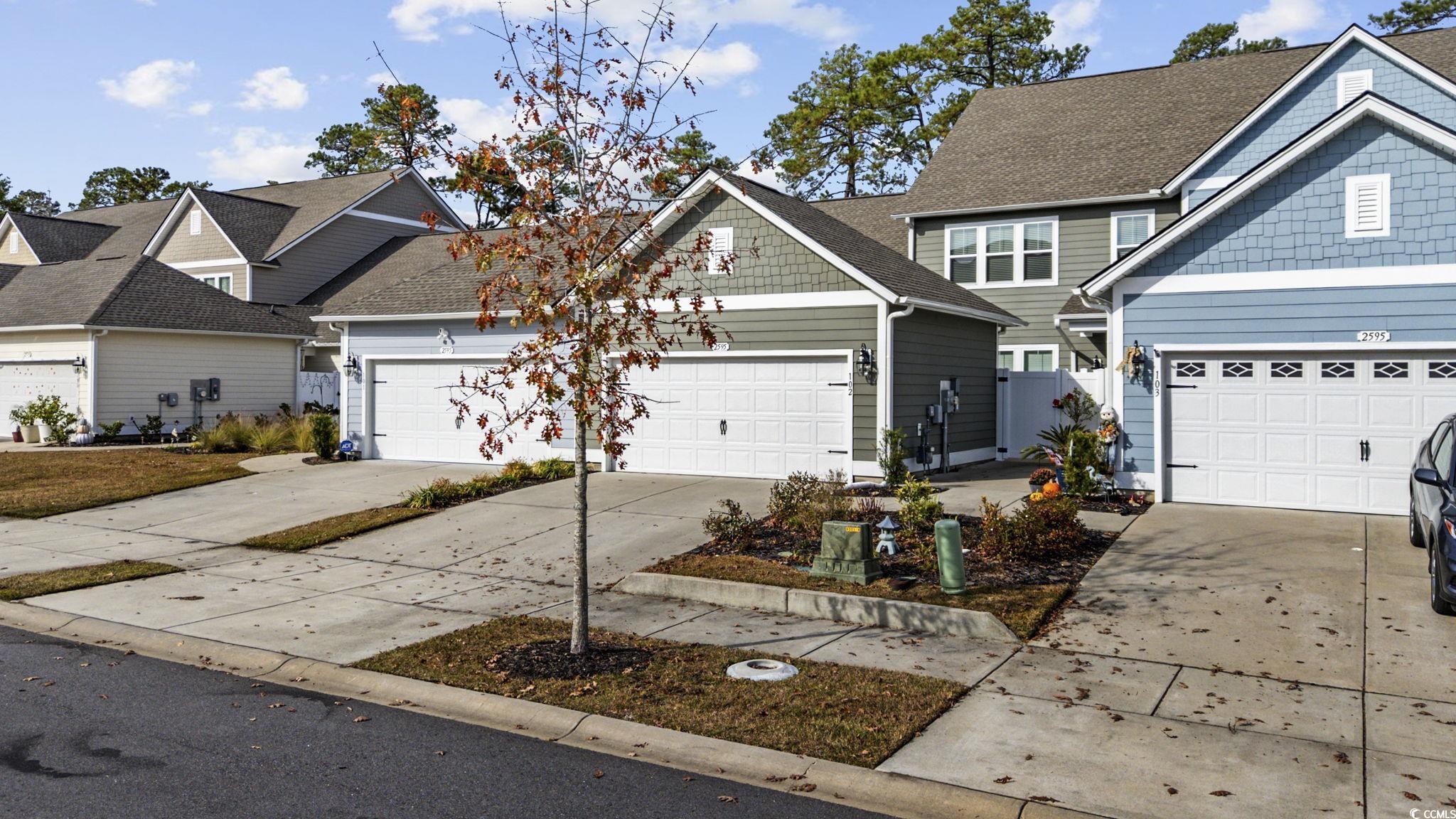 2595 Blue Crane Circle, Unit 102 Myrtle Beach, SC 29577 - Photo 2 of 40 View of front of property featuring concrete driveway, roof with shingles, and an attached garage