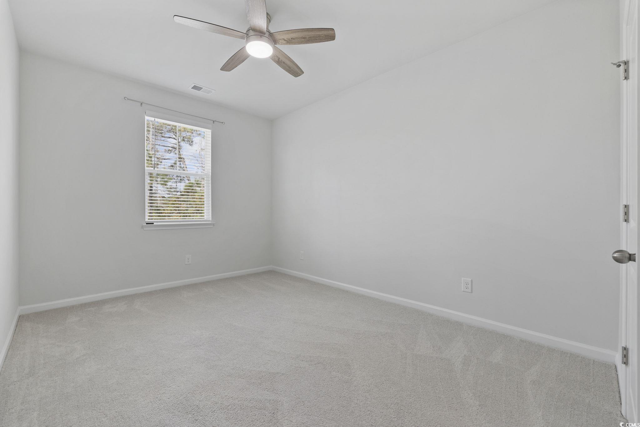 2595 Blue Crane Circle, Unit 102 Myrtle Beach, SC 29577 - Photo 28 of 40 Empty room with light colored carpet and a ceiling fan