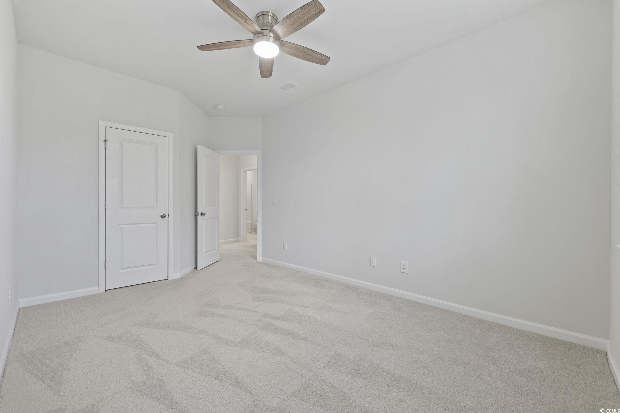 2595 Blue Crane Circle, Unit 102 Myrtle Beach, SC 29577 - Photo 30 of 40 Unfurnished bedroom with light colored carpet and ceiling fan