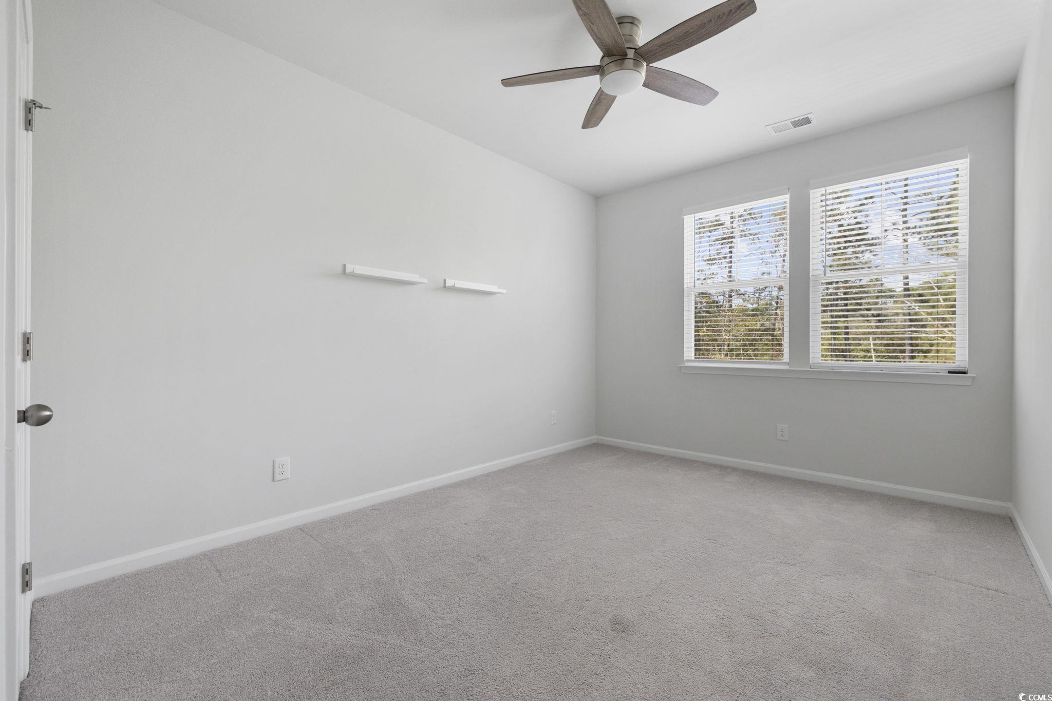 2595 Blue Crane Circle, Unit 102 Myrtle Beach, SC 29577 - Photo 31 of 40 Empty room with light colored carpet and a ceiling fan