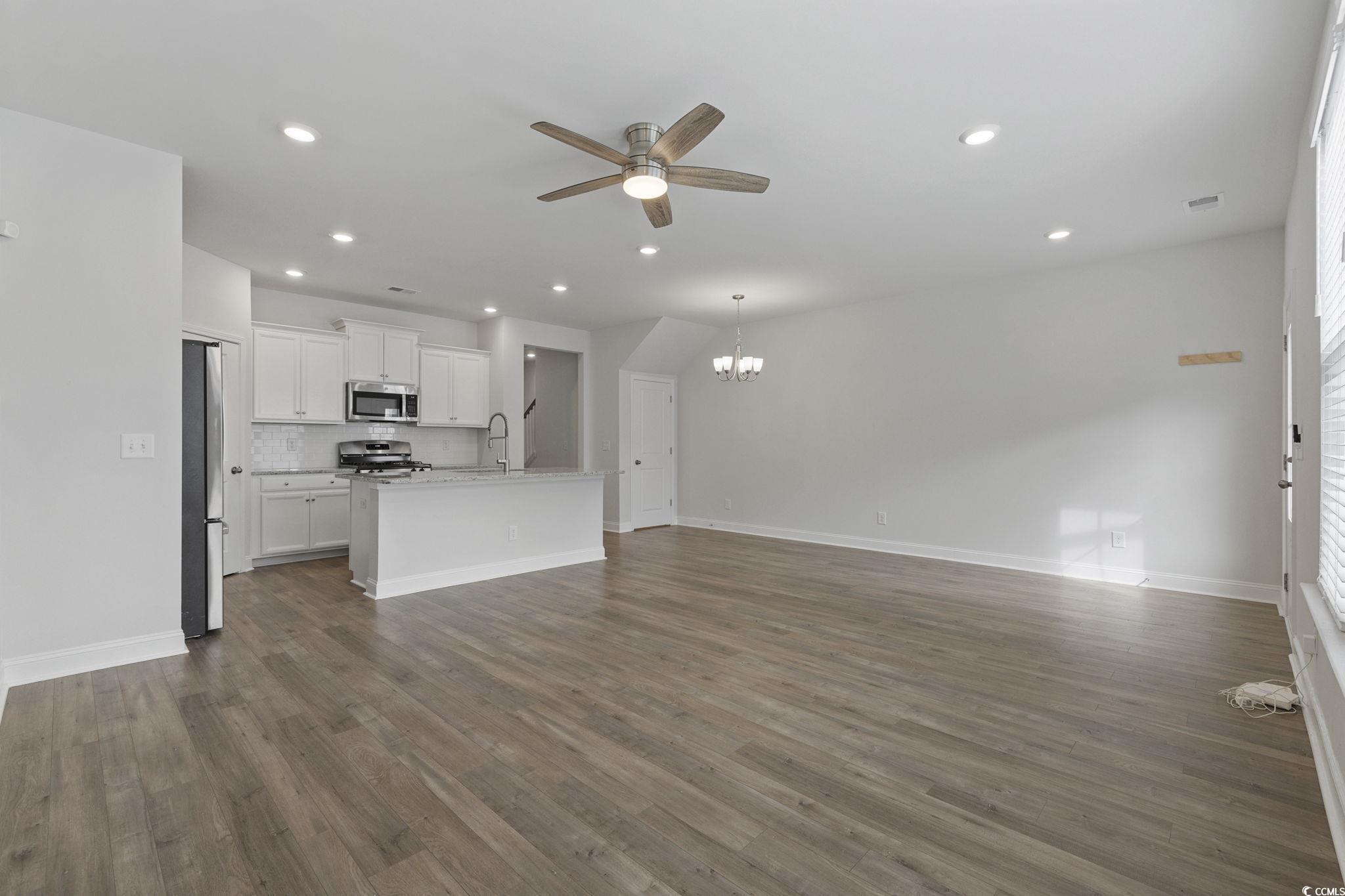2595 Blue Crane Circle, Unit 102 Myrtle Beach, SC 29577 - Photo 8 of 40 Unfurnished living room with a ceiling fan, dark wood-style flooring, a chandelier, and recessed lighting