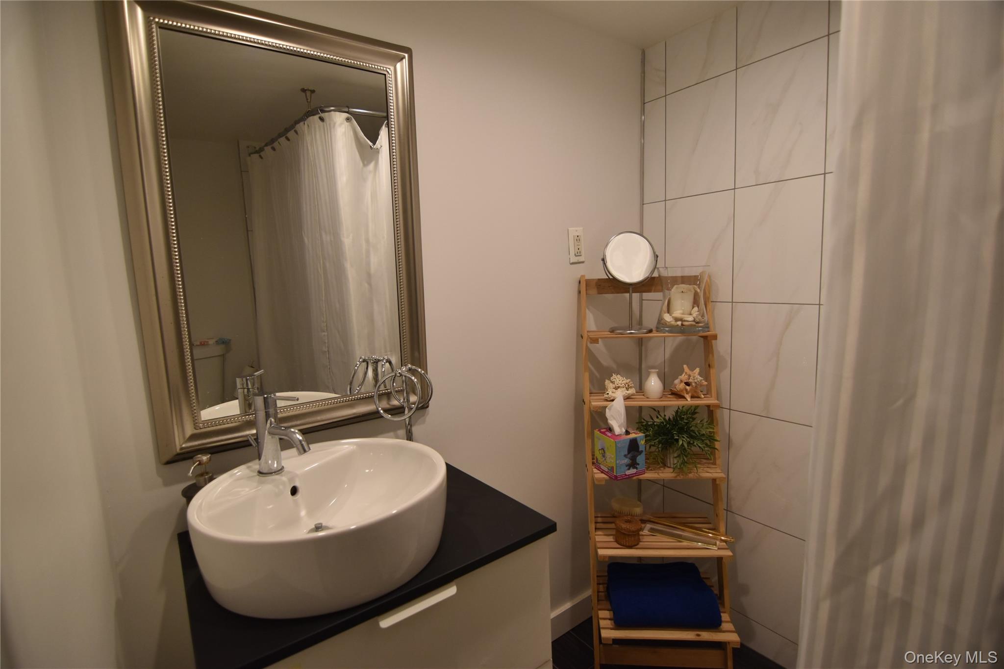 25-48 89th Street Queens, NY 11369 - Photo 13 of 17 a bathroom with a sink and mirror