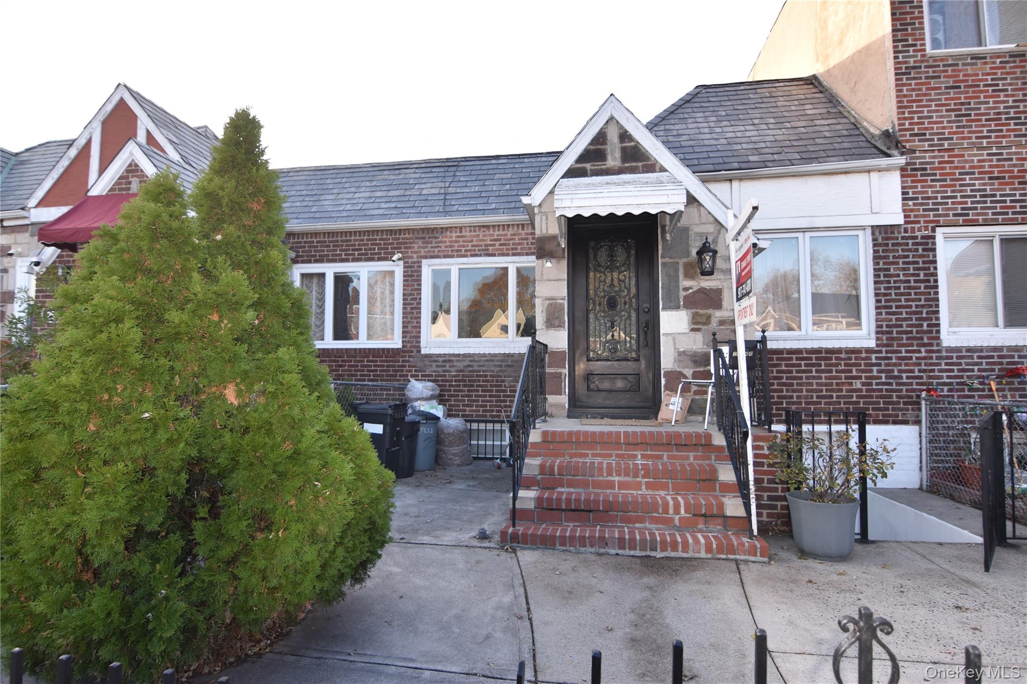 25-48 89th Street Queens, NY 11369 - Photo 2 of 17 a front view of a house with a garden