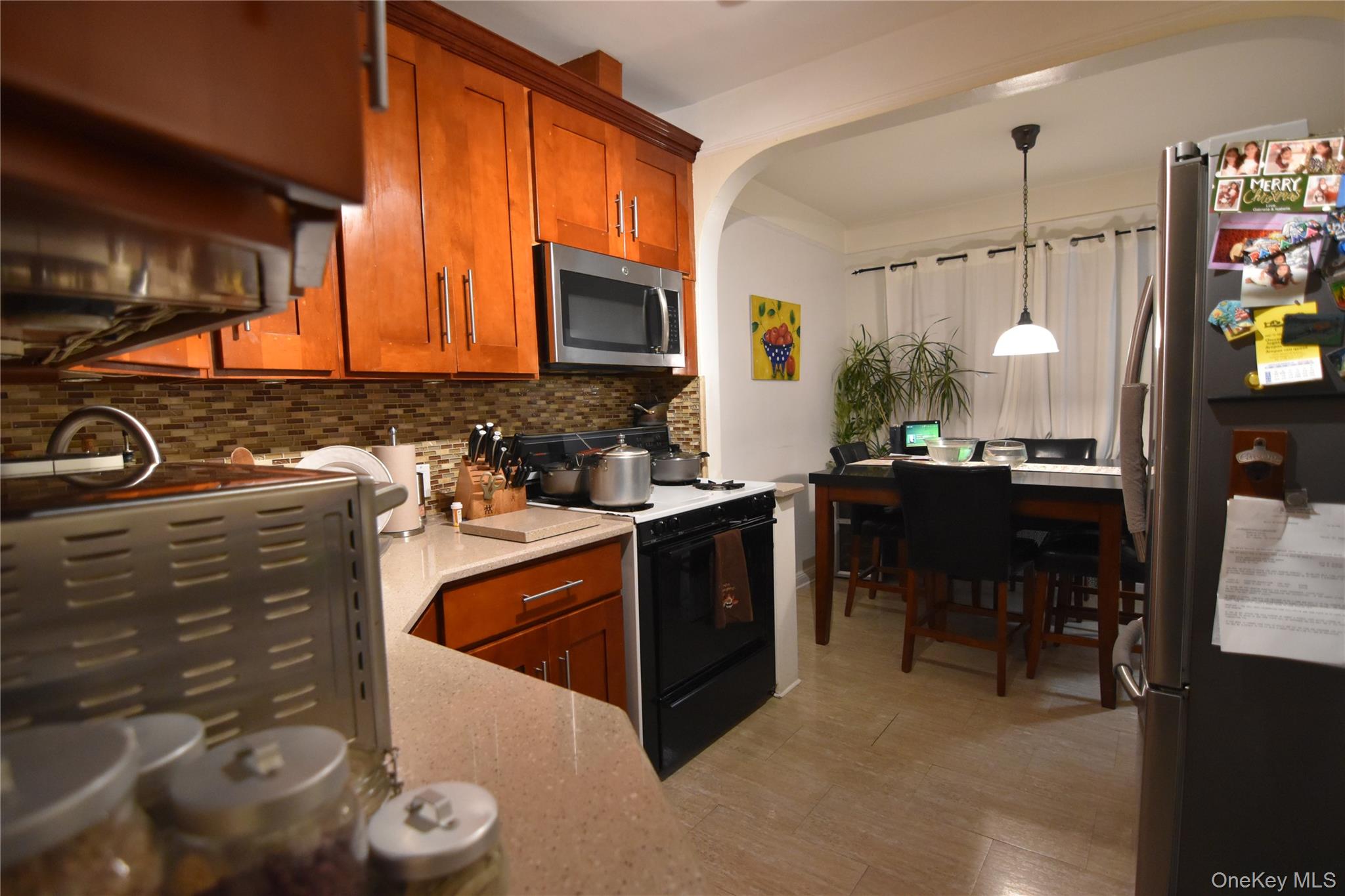25-48 89th Street Queens, NY 11369 - Photo 3 of 17 a kitchen with stainless steel appliances granite countertop a sink wooden cabinets and a granite counter tops
