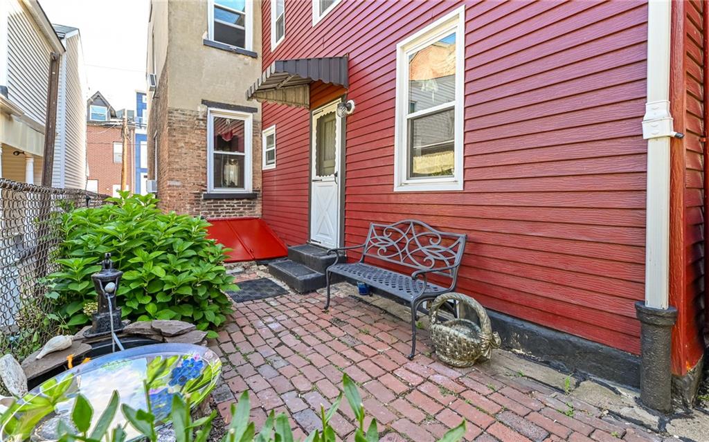 164 45th Street Pittsburgh, PA 15201 - Photo 30 of 47 a bench and some potted plants in front of a building