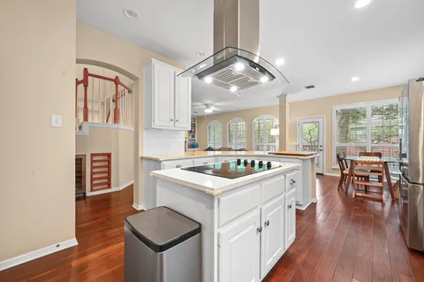 a kitchen with a stove and wooden floor