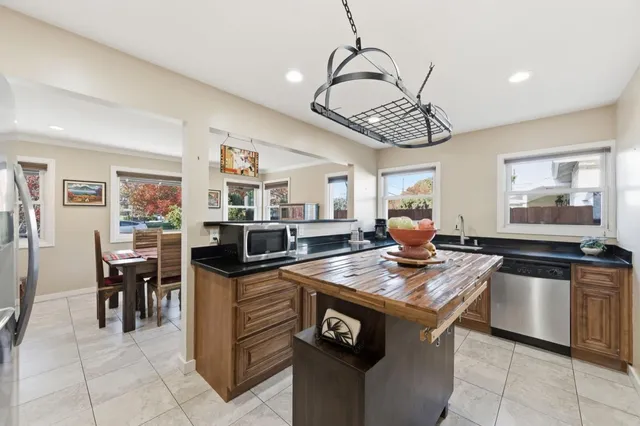 a kitchen with stainless steel appliances granite countertop a sink a stove and a refrigerator