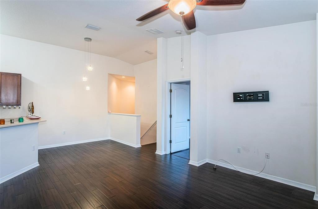 9013 Moonlit Meadows Loop Riverview, FL 33578 - Photo 12 of 43 an empty room with wooden floor chandelier fan and windows