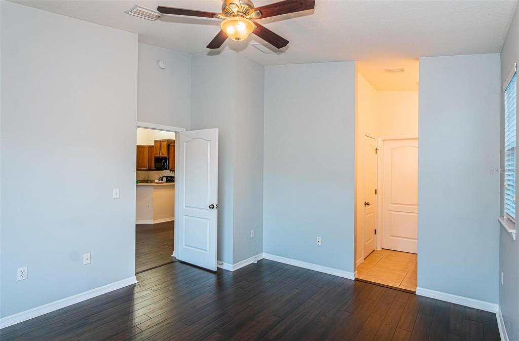 9013 Moonlit Meadows Loop Riverview, FL 33578 - Photo 8 of 43 a view of an empty room with wooden floor and a window