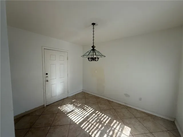 a view of a room with a chandelier fan and wooden floor