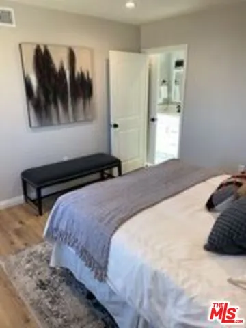 a bedroom with a bed and a painting on the wall
