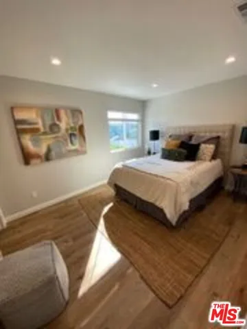 a bedroom with a bed and a painting on the wall