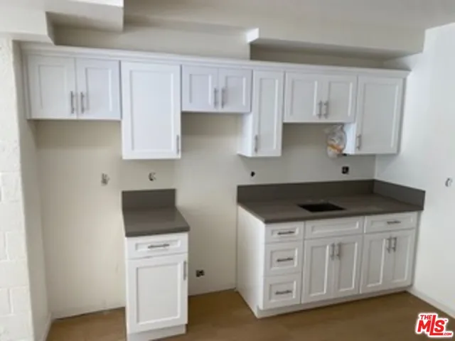 a kitchen with stainless steel appliances granite countertop a stove a sink and a white cabinets