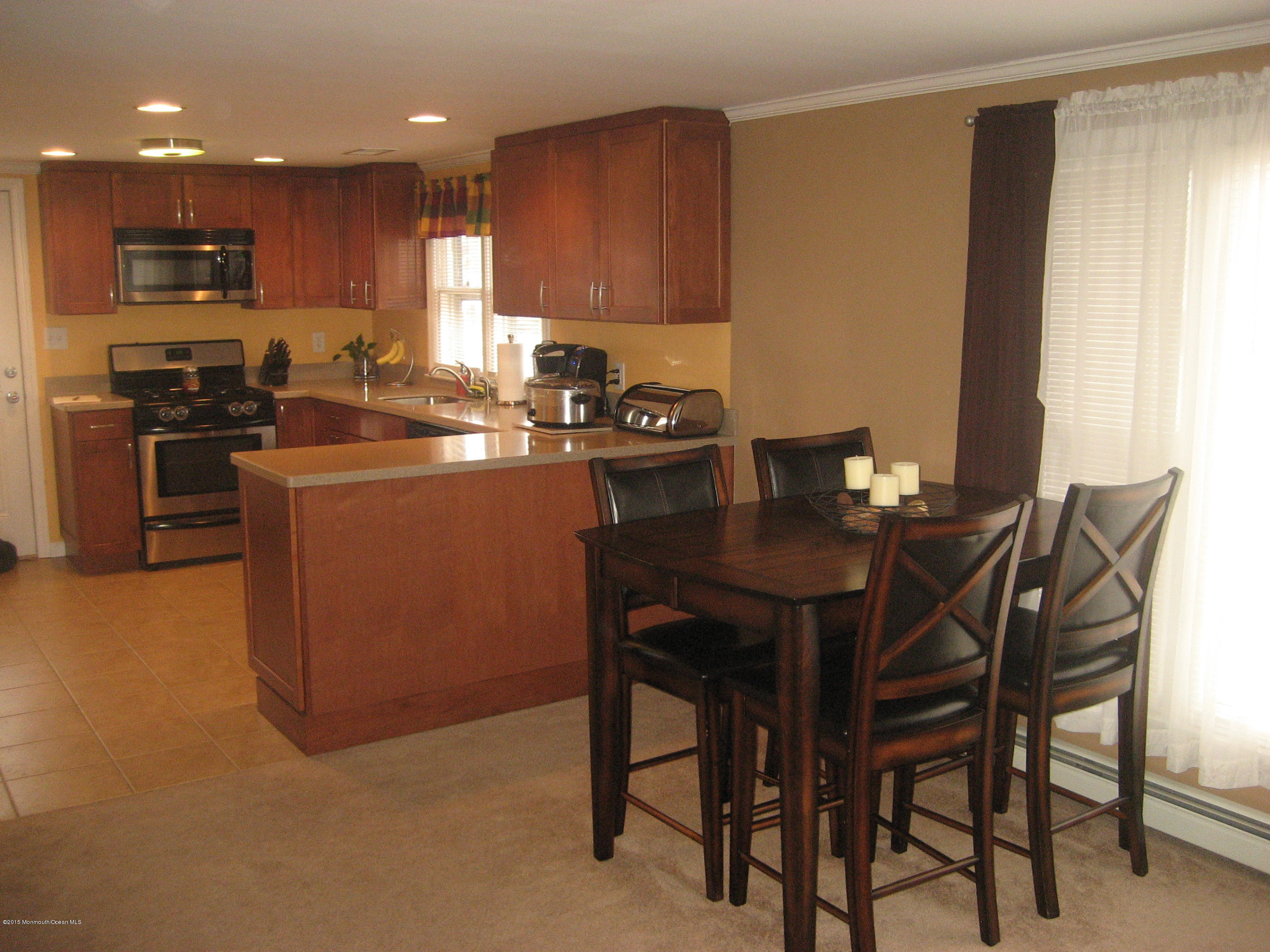 134 Club House Road Brick, NJ 08723 - Photo 3 of 20 a kitchen with a table chairs microwave and cabinets