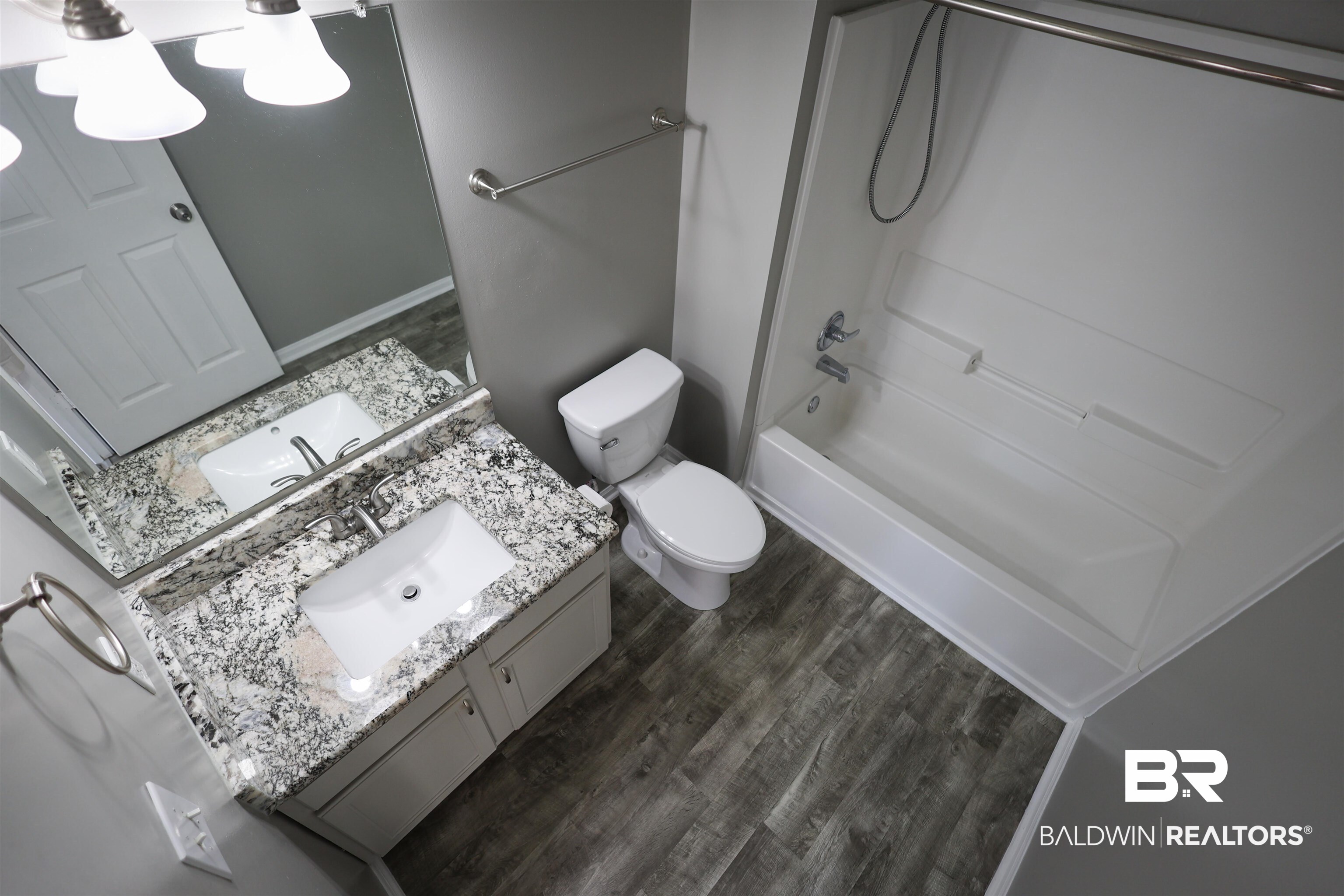 1517 Regency Road, Unit 125 Gulf Shores, AL 36542 - Photo 22 of 26 Bathroom featuring dark wood-style floors, vanity, and bathing tub / shower combination