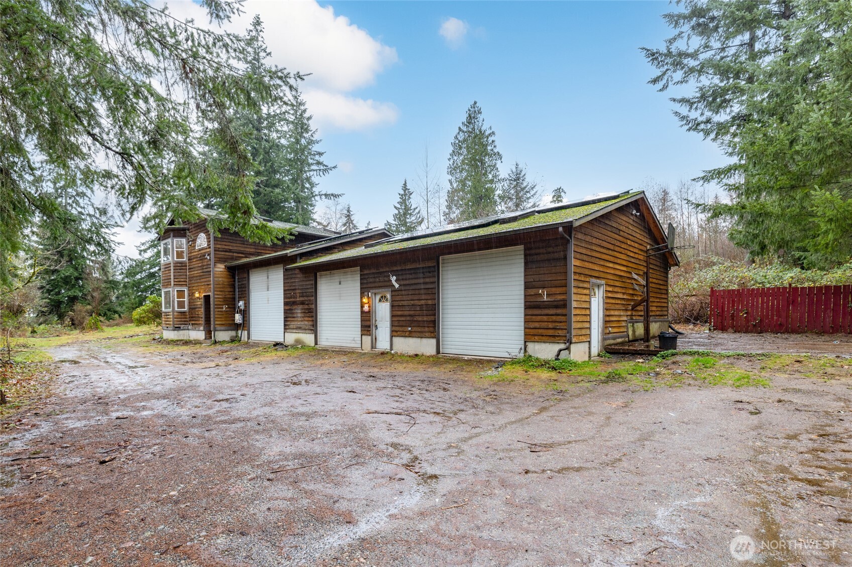 a view of a house with a yard and large trees