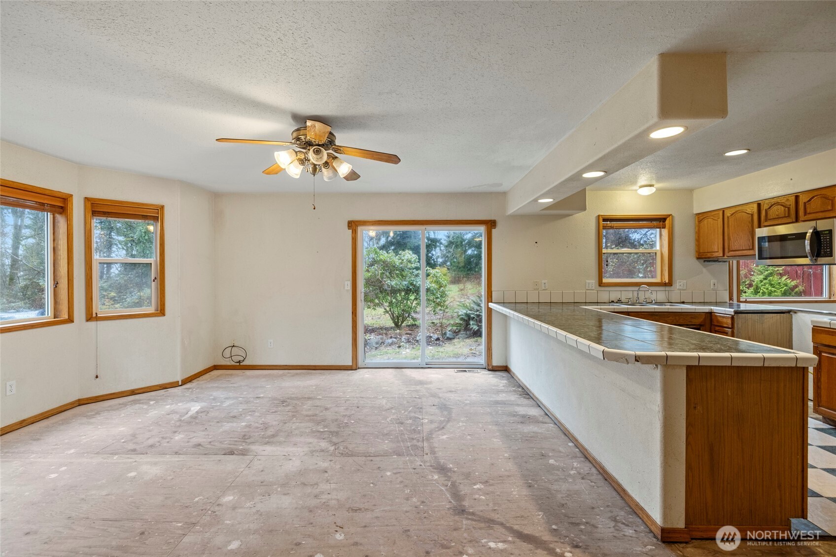7308 Valley View Road Sedro-Woolley, WA 98284 - Photo 21 of 38 a view of a kitchen with kitchen island wooden floor and a ceiling fan