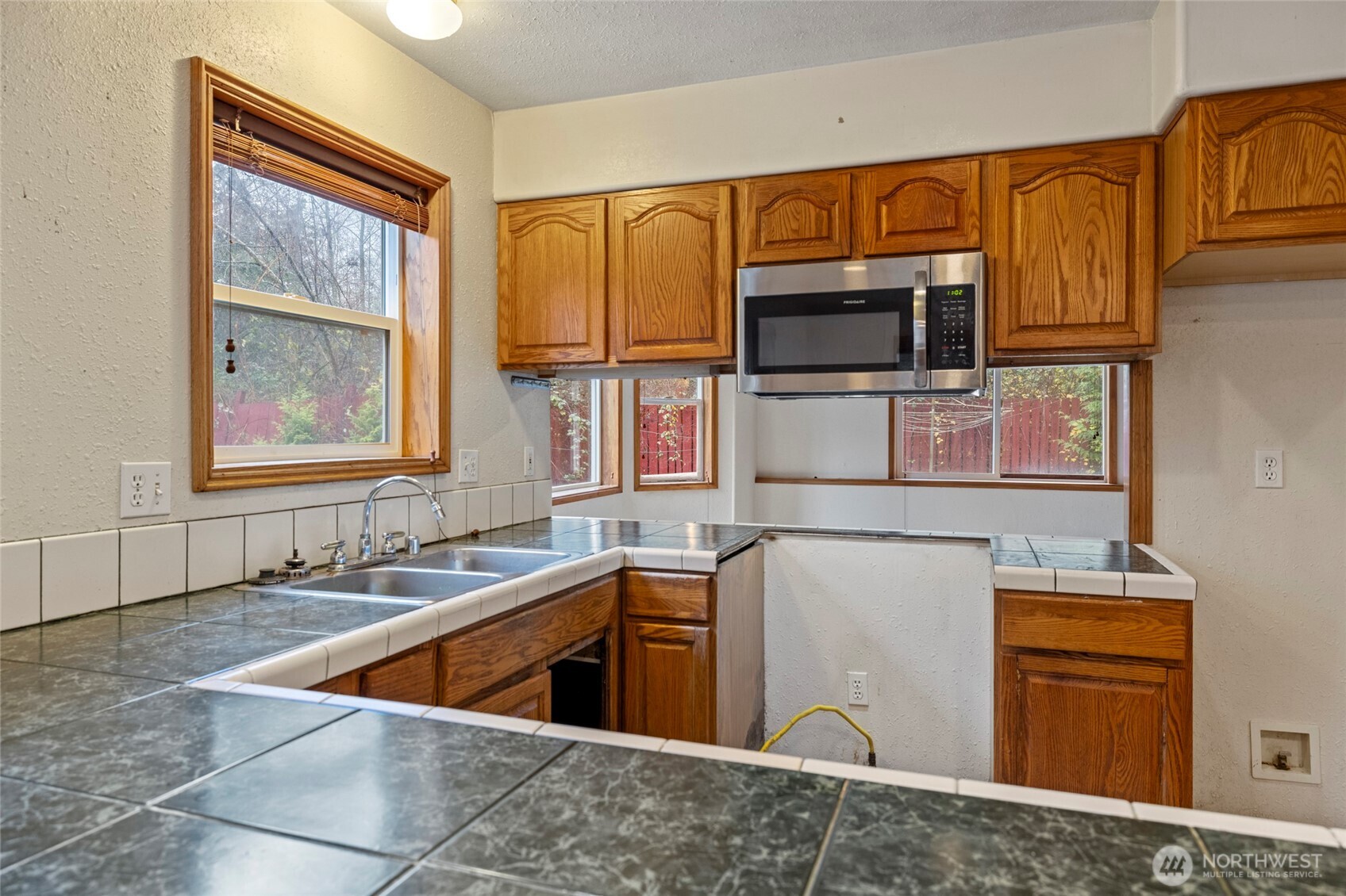 7308 Valley View Road Sedro-Woolley, WA 98284 - Photo 25 of 38 a kitchen with stainless steel appliances granite countertop a sink and a microwave