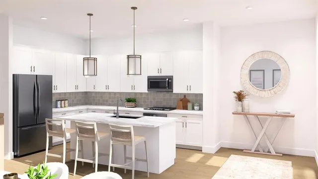 a kitchen with stainless steel appliances kitchen island granite countertop a sink a stove and refrigerator