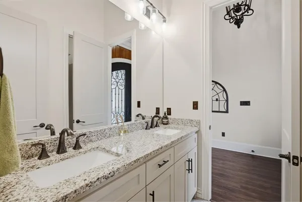 a bathroom with a granite countertop sink and a mirror