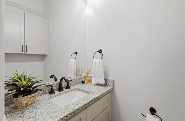 a bathroom with a granite countertop sink and a mirror