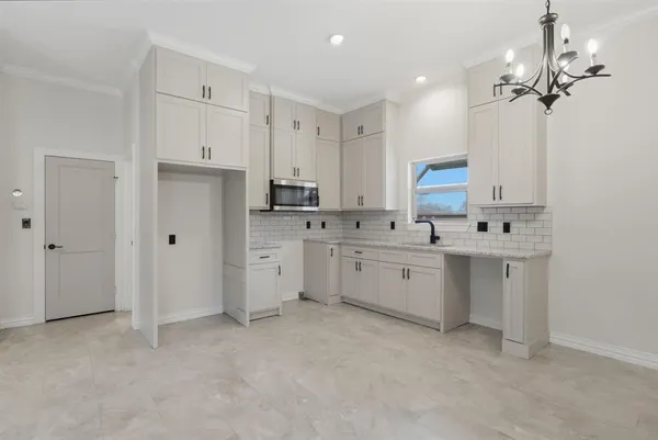 a kitchen with white cabinets stainless steel appliances and a sink