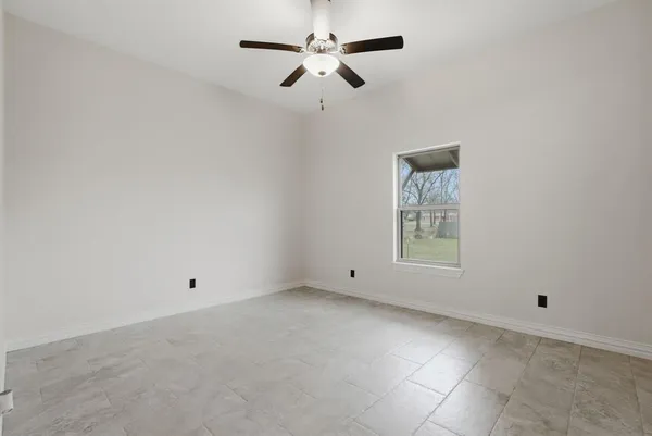 an empty room with fan and windows