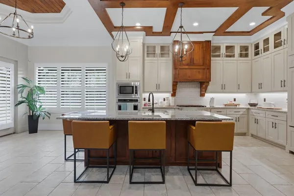 a kitchen with a table chairs sink and cabinets