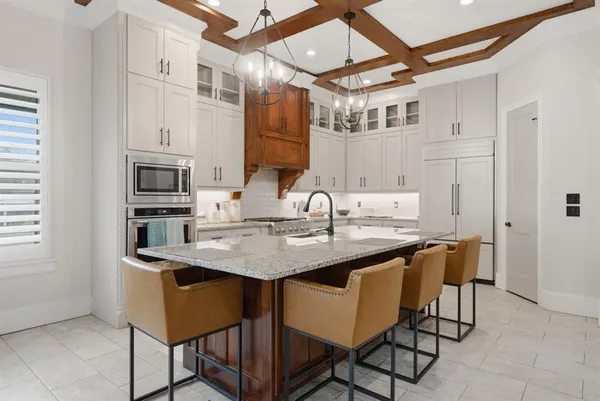 a kitchen with stainless steel appliances granite countertop a sink and a refrigerator