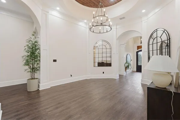 an empty room with wooden floor and potted plant