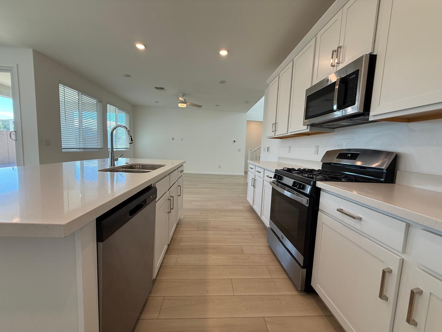 17760 West Cassia Way Goodyear, AZ 85338 - Photo 14 of 37 a kitchen with stainless steel appliances granite countertop a sink a stove top oven and granite counter tops