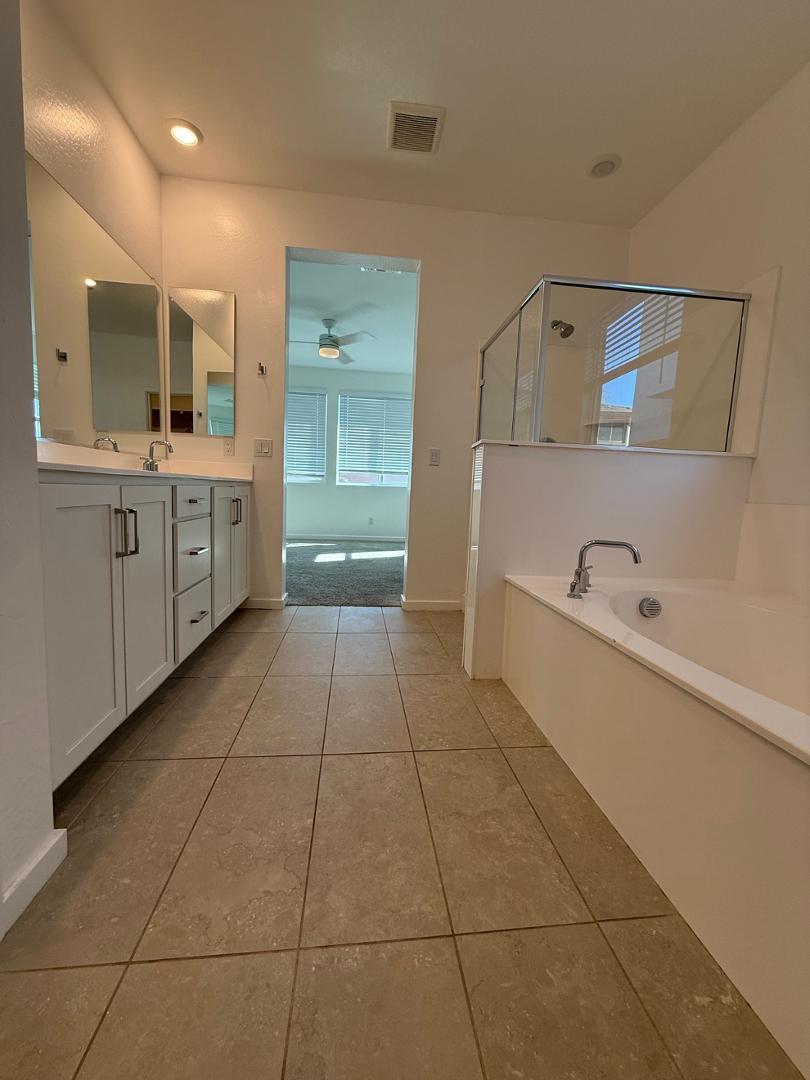 17760 West Cassia Way Goodyear, AZ 85338 - Photo 21 of 37 a large bathroom with a granite countertop sink a toilet and mirror