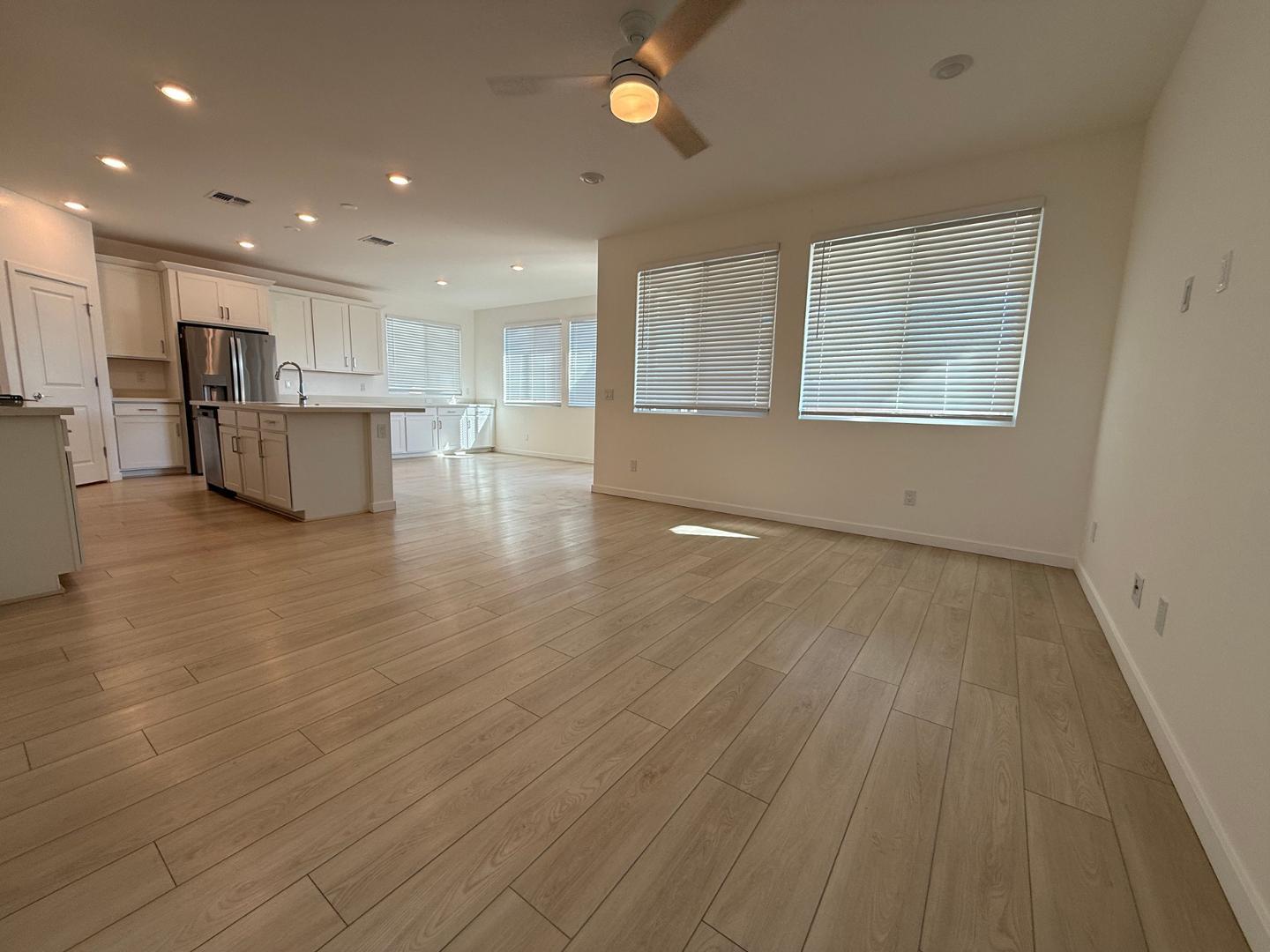 17760 West Cassia Way Goodyear, AZ 85338 - Photo 5 of 37 an empty room with wooden floor and windows