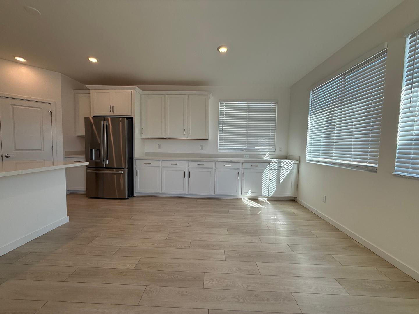 17760 West Cassia Way Goodyear, AZ 85338 - Photo 10 of 37 a view of kitchen with refrigerator cabinets and wooden floor
