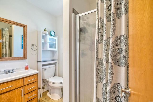 a bathroom with a granite countertop sink toilet and shower