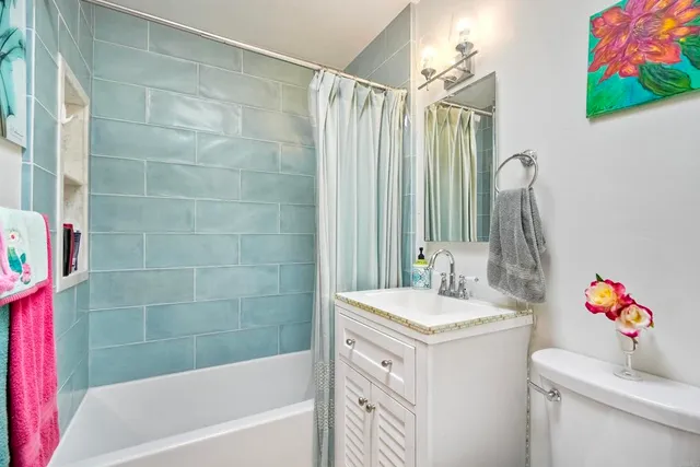 a bathroom with a sink vanity mirror and toilet