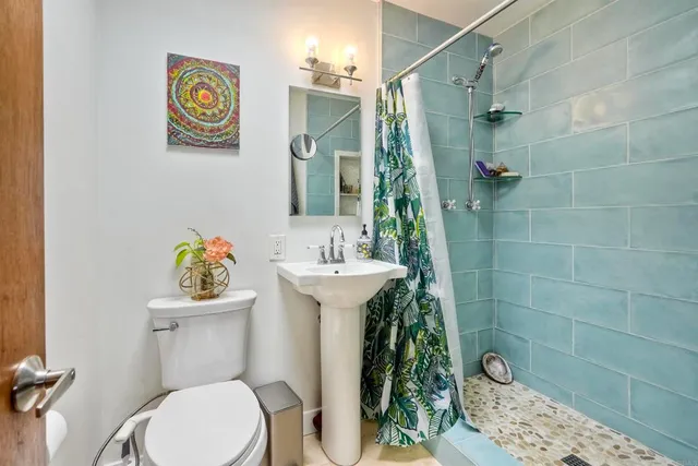 a bathroom with a sink mirror and toilet