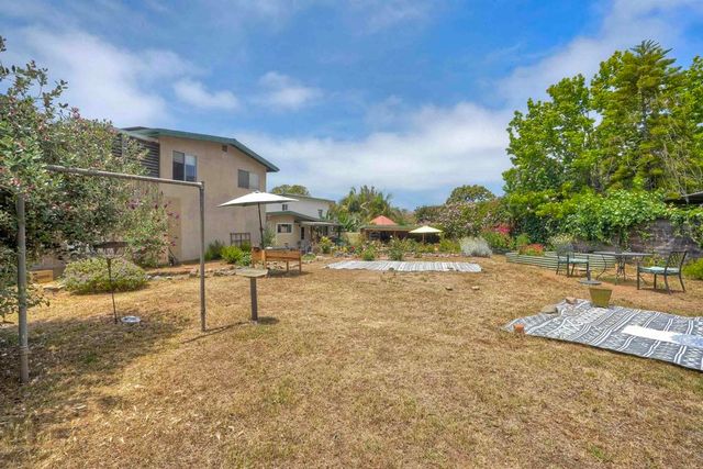 a view of a house with backyard and sitting area