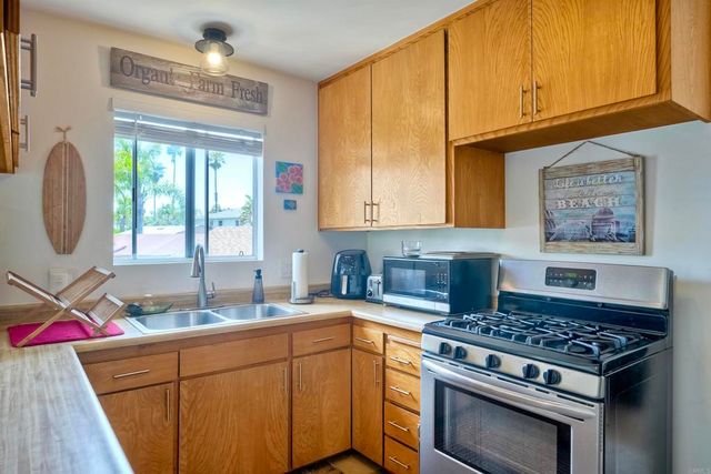 a kitchen with stainless steel appliances granite countertop a stove a sink and a microwave