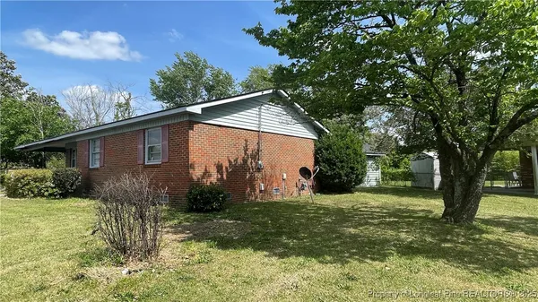 a view of a house with backyard and a tree