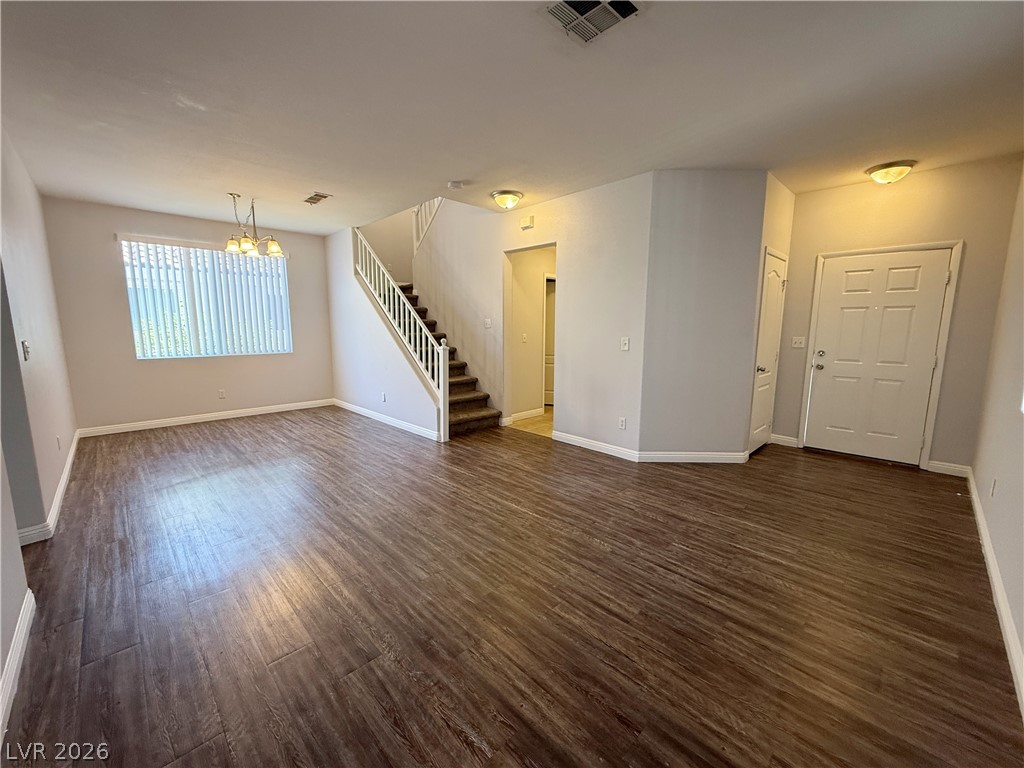 2185 Polynesia Circle Henderson, NV 89074 - Photo 3 of 37 A spacious, naturally illuminated room featuring rich wood flooring and an inviting staircase.