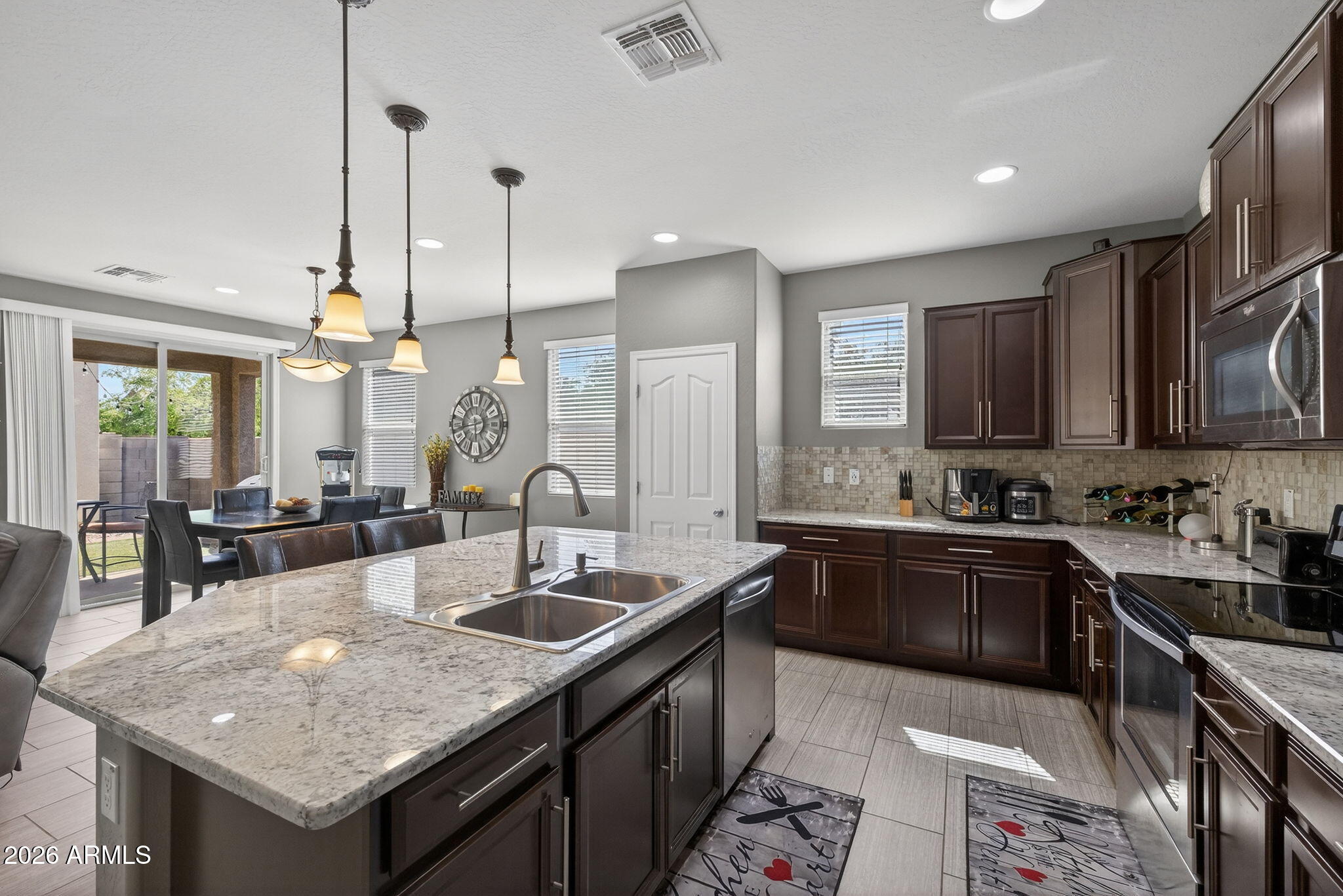921 South Swallow Lane Gilbert, AZ 85296 - Photo 11 of 36 a kitchen with granite countertop a sink stove and cabinets