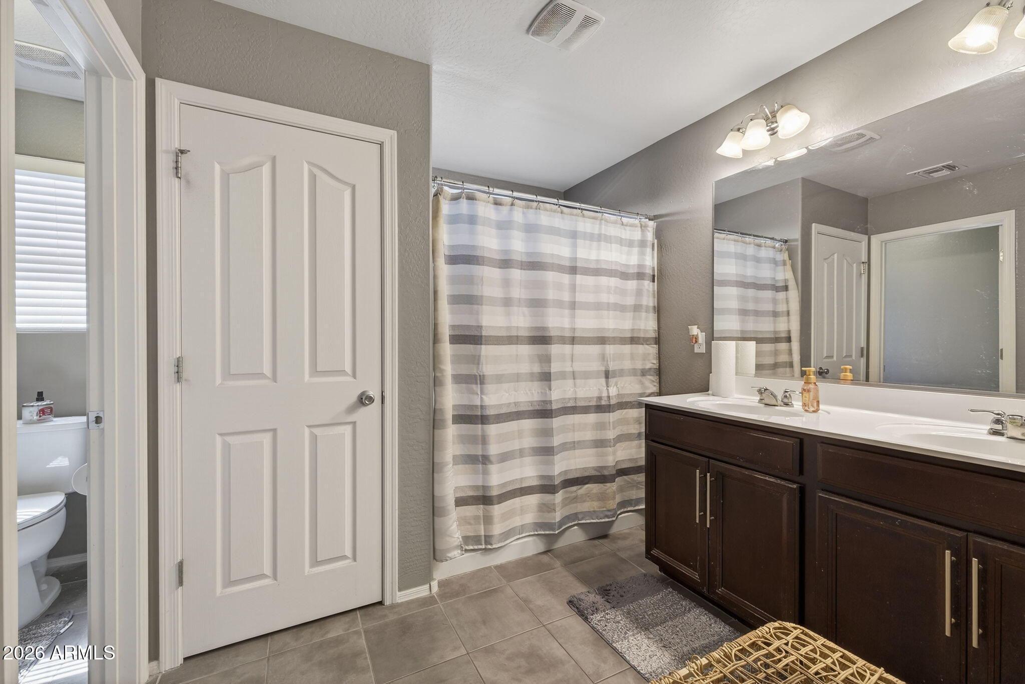 921 South Swallow Lane Gilbert, AZ 85296 - Photo 22 of 36 a bathroom with a double vanity sink a toilet and a mirror