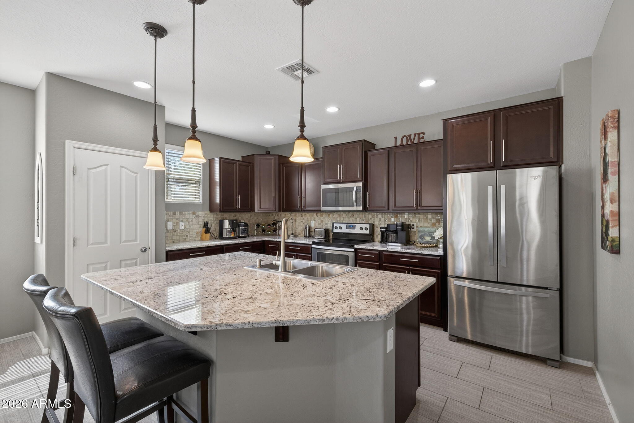921 South Swallow Lane Gilbert, AZ 85296 - Photo 8 of 36 a kitchen with kitchen island a counter space a center island stainless steel appliances and cabinets